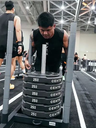 Ac moving a weighted sled during a Hyrox race